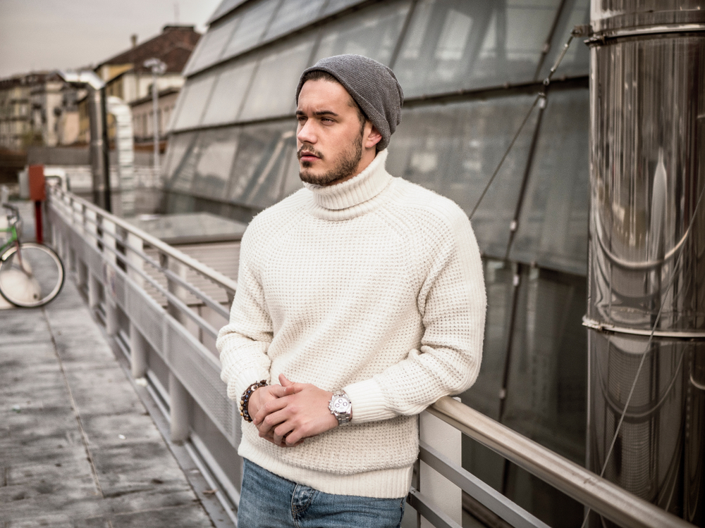barbat in pulover si pantaloni si cu fes pe cap
